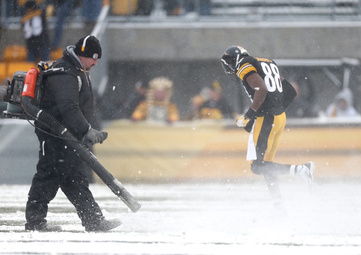 A Steelers worker uses a leaf blower to clear the lines.