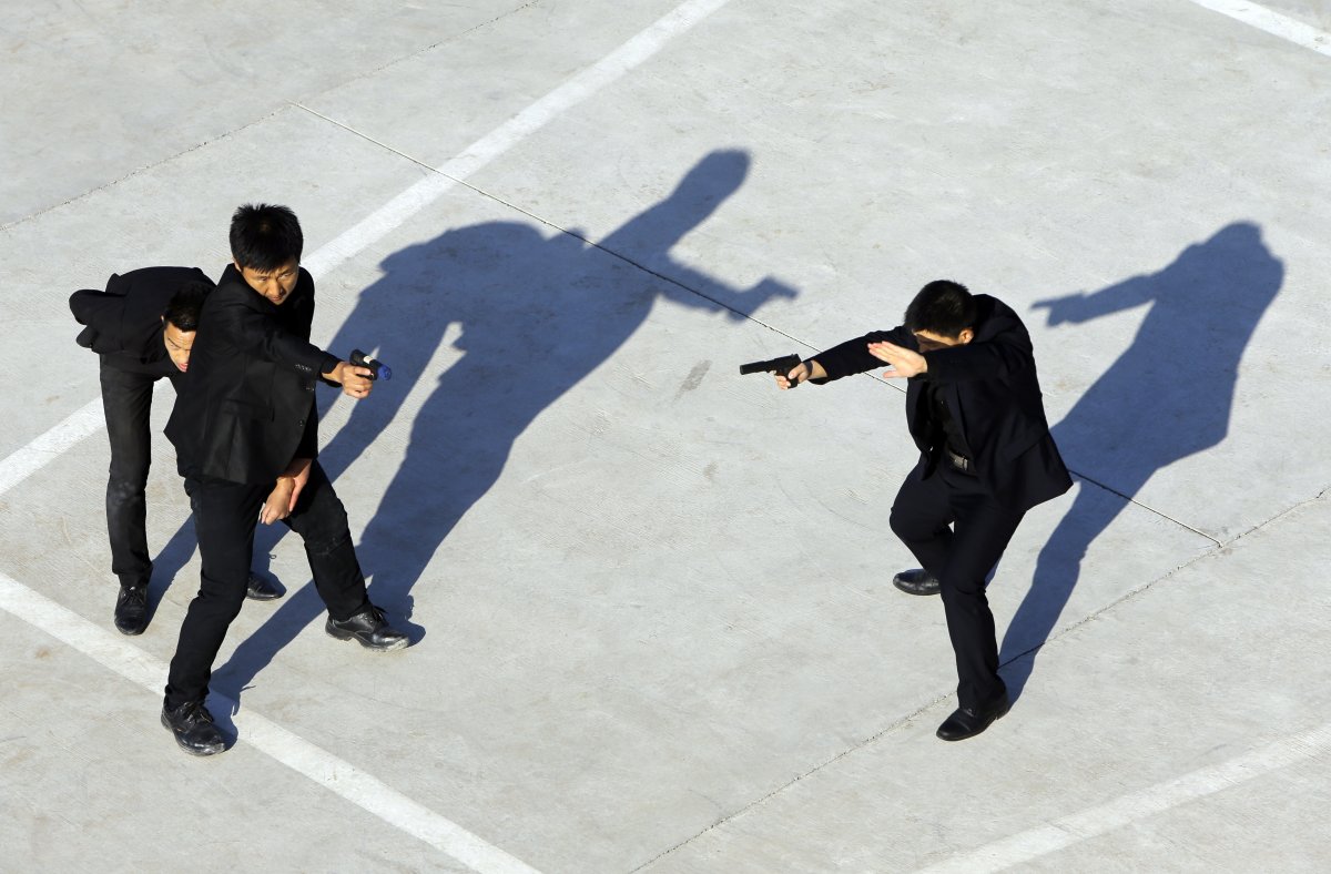 Trainees point replica pistols as they take part in a training session at the Tianjiao Special Guard Security Consultant training camp on the outskirts of Beijing.