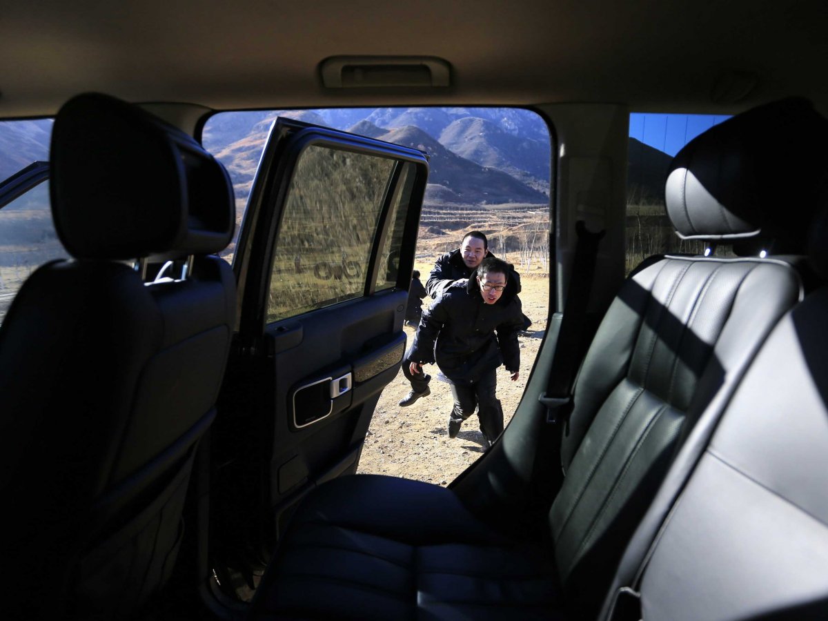 Trainees practice helping their employer escape into a car at a shooting training field managed by the military.