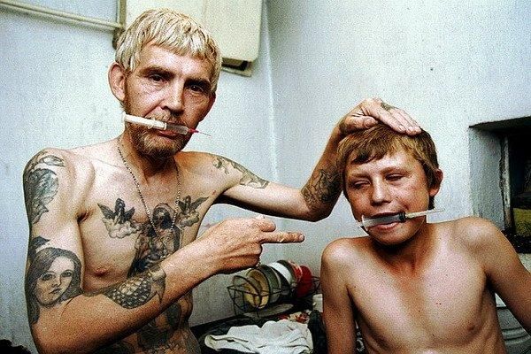 Father showing his son how to shoot heroin.