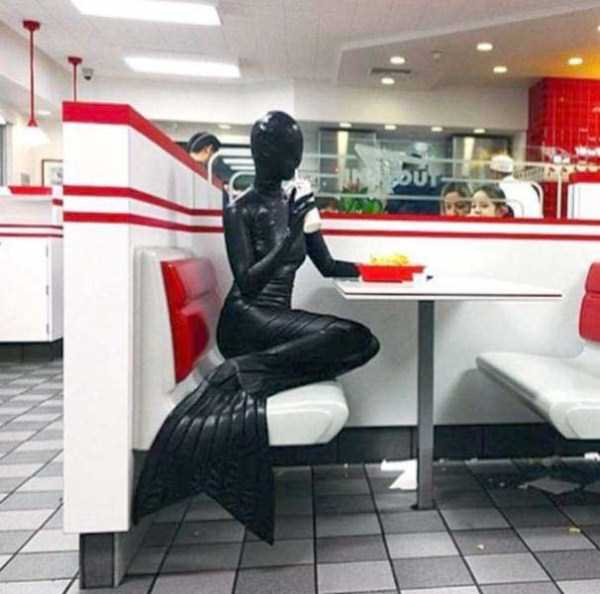 kink dungeon mermaid in a restaurant booth