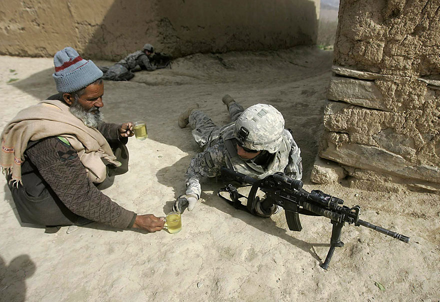 Afghan man offers tea to soldiers.