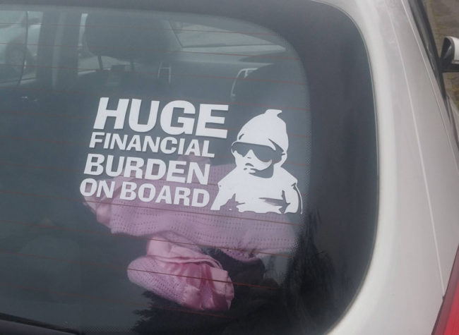 Funny sticker someone put in their car warning that their kid is a huge financial burden.