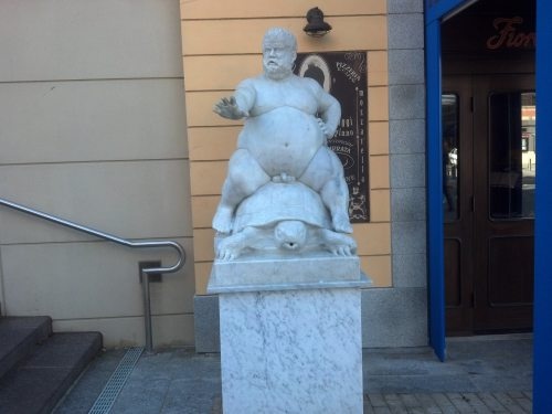 Statue of a fat man riding a turtle