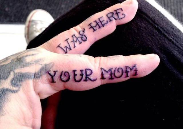 Tattoo of Your Mom Was Here on someone's fingers.