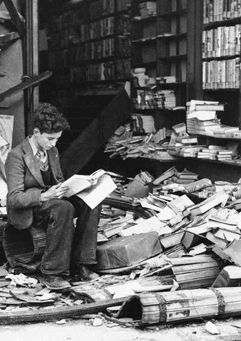 A man reads a book outside of a bookstore that was destroyed in London bombings