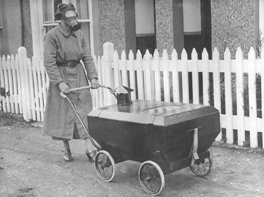 A woman taking her baby for a walk in a gas proof pram
