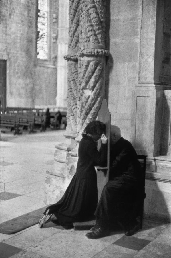 A woman gives her confession at the Jerónimos Monastery in Lisbon, Portugal in 1955.