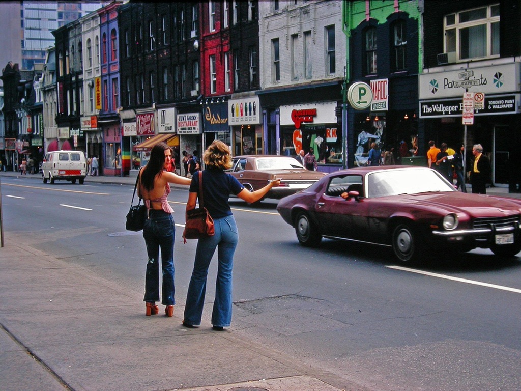 2 women hitchhiking in Toronto, Canada in 1974. It is possible these 2 found the only time of day and the only street in the country without nice Canadians to assist them. That, or a big hockey game may have been taking place at the same time.