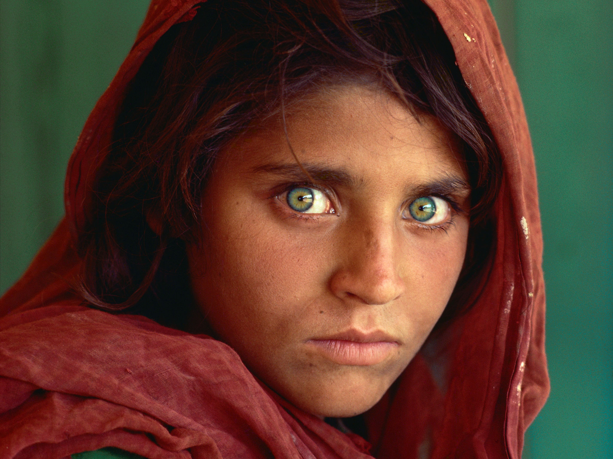 Afghan Girl - Taken by Steve McCurry during the Soviet occupation of Afghanistan, this transfixing image depicts a refugee from the war and was used for the cover the June 1985 issue of National Geographic. The subject was only identified 17 years later as Sharbat Gula, and she had never actually seen her iconic portrait before McCurry managed to track her down in January 2002.