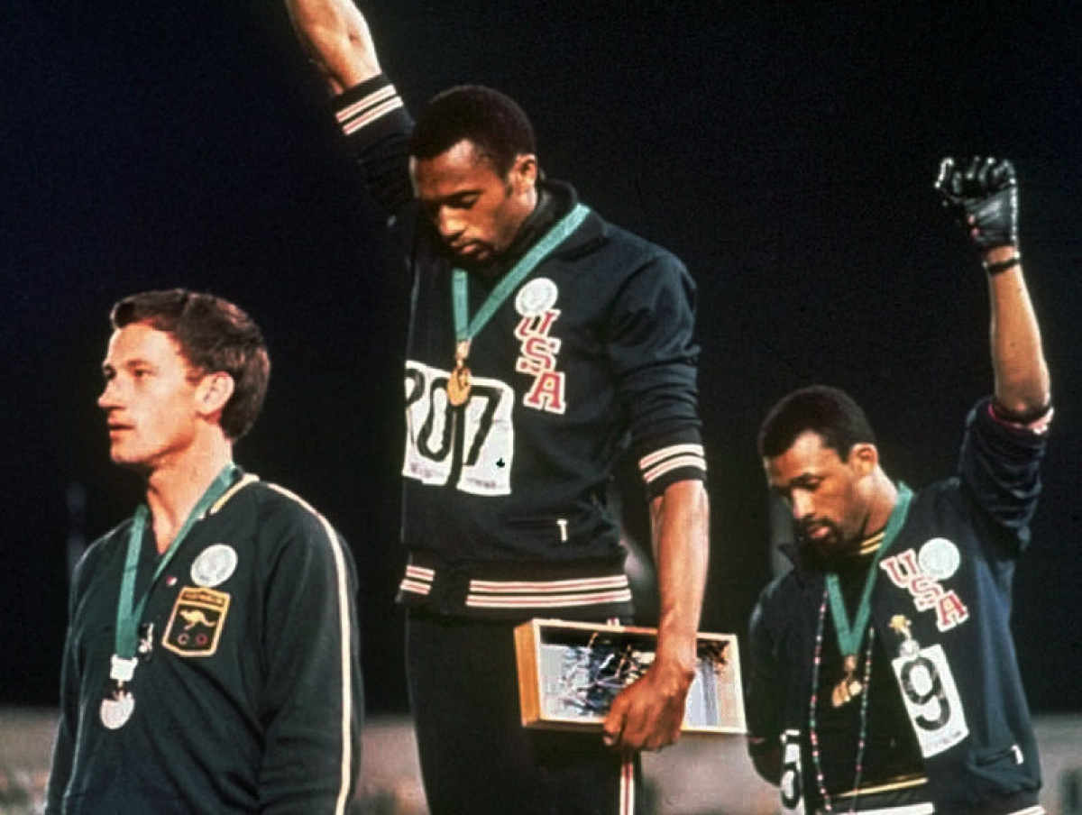 Black Power Salute - When African-American Olympic sprinters Tommie Smith and John Carlos stood atop the medal podium in Mexico City, 1968, heads bowed and black-gloved fists raised during the playing of the national anthem, many were outraged but many more were thrilled and inspired by their Black Power salute. John Dominis’ photo endures to this day as a symbol of expressed disillusionment with the promise of a nation. In the photo, Smith stands in black socks with his running shoes off in a gesture meant to symbolize black poverty.

Australian silver medalist Peter Norman stood and displayed solidarity with them, wearing an Olympic Project for Human Rights badge during the ceremony. In 2006, both Smith and Carlos were pallbearers at Norman’s funeral.