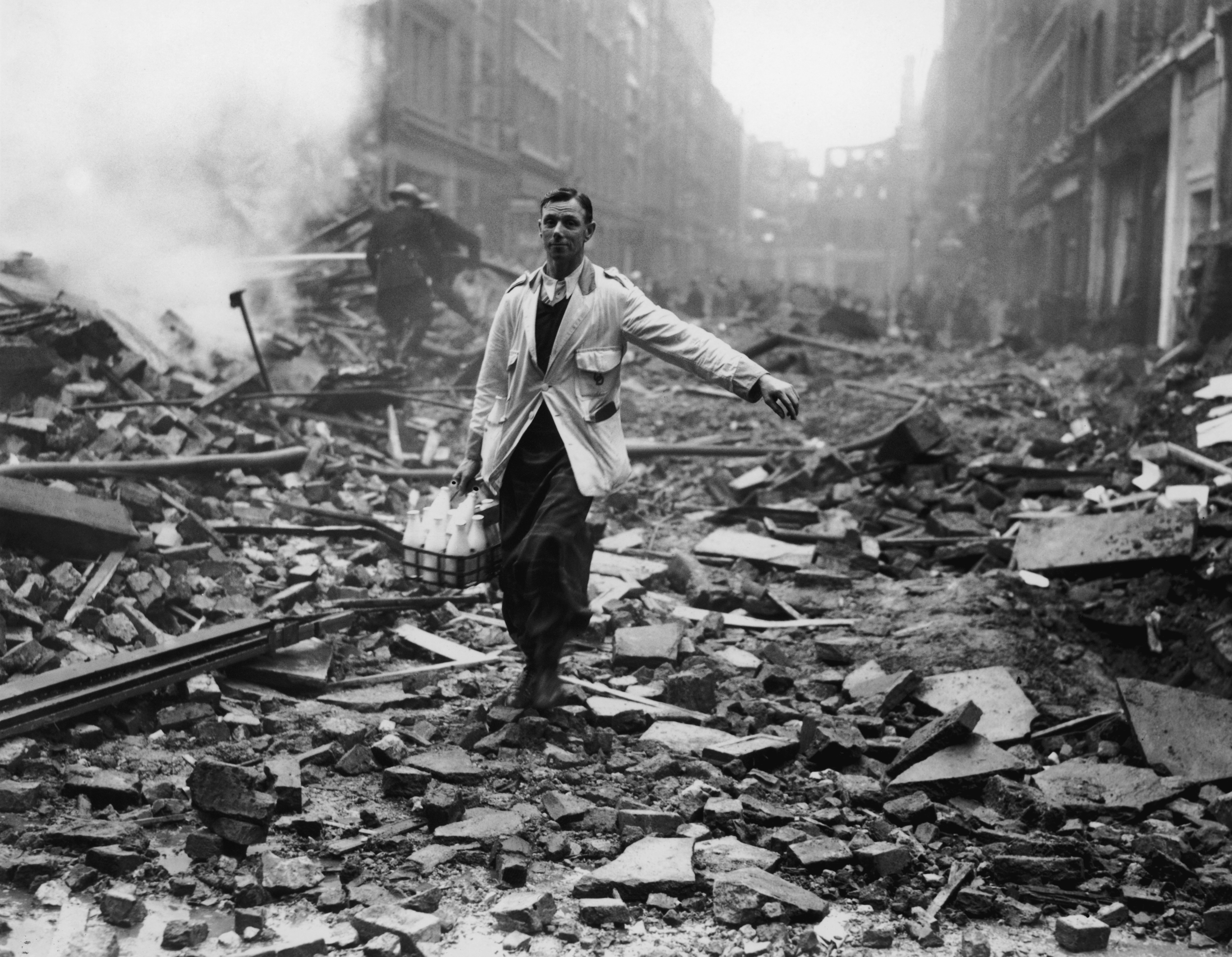 The London Milkman - Taken by Fred Morley during the London blitz on October 9, 1940, this photo portrays a milkman making his rounds on foot despite the devastation around him. Intended to raise spirits by potently displaying the spirit of British stoicism during wartime, the picture was actually staged. Morley’s assistant borrowed a milkman’s outfit and a bottle rack, and Morley found some firefighters for him to pose in front of. The government censors had restricted the publication of anything that might cause panic, but Morley circumvented this by depicting normal life carrying on despite the carnage. It worked, and the photo was published the next day.