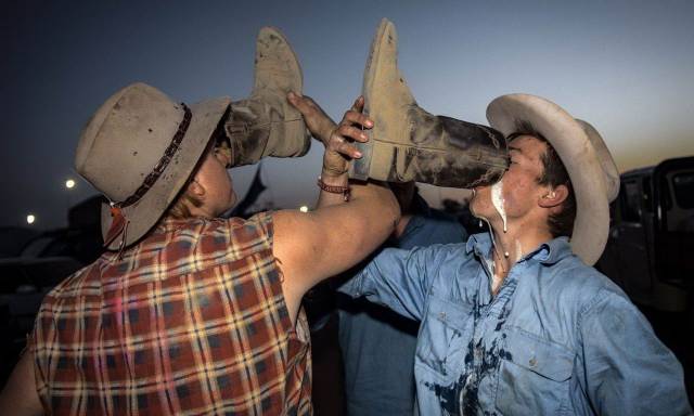 Weird picture of two cowboys drinking beer out of their dirty boots