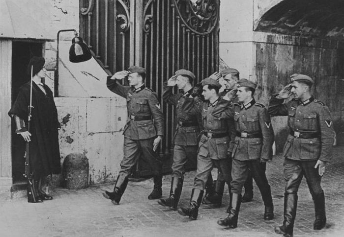 German Soldiers salute a Swiss Guard.