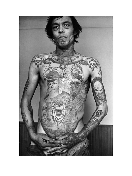 This prisoners tattoos display his anger and bitterness towards Communist power the tattoos on the face signify that he never expects to go free. He works as a stoker. Text under the eyes reads Full  of Love on the chin Danger of Death around the neck To each his own above each head of the double-headed snake Wife and Mother-in-law on the chest It is not for you whores, to dig in my soul on his arm Communists, suck my dick for my ruined youth.