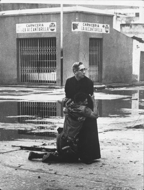 Priest Luis Padillo offers last rites to a loyalist soldier who is mortally wounded by a sniper during military rebellion against President Btancourt at Puerto Cabello naval base in Venezuela