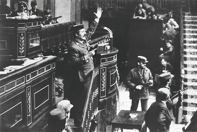 Lt. Col. Antonio Tejero Molina orders everyone to remain seated and be quiet after armed Guardia Civil soldiers stormed the Assembly Hall of the Spanish Parliament. Three hundred deputies and cabinet members were in session to vote upon the succession of premier Suarez. They were released next morning after having been held hostage for almost 18 hours the coup was a failure.
