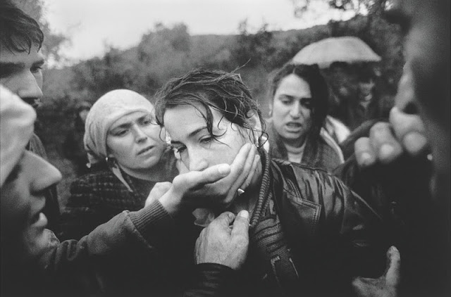 A woman is comforted by relatives and friends at the funeral of her husband. The man was a soldier with the ethnic Albanian rebels of the Kosovo Liberation Army, fighting for independence from Serbia. He had been shot the previous day while on patrol