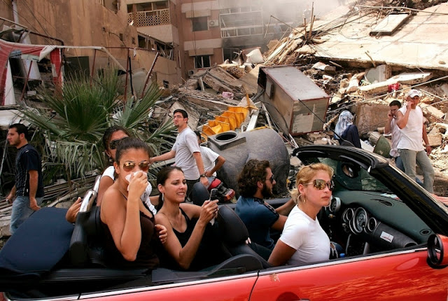 Young Lebanese drive down a street in Haret Hreik, a bombed neighborhood in southern Beirut.