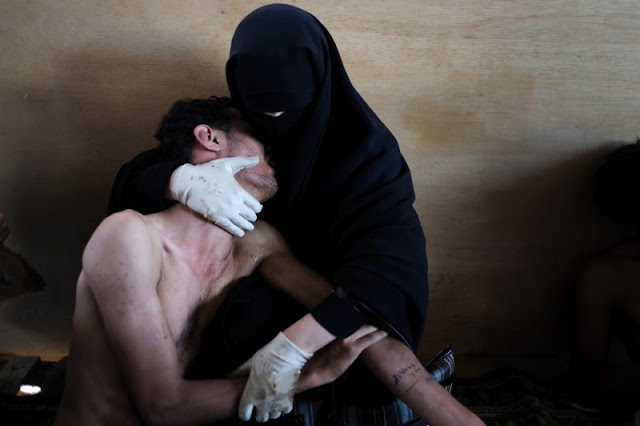 A veiled woman holds a wounded relative "inside a mosque used as a field hospital by demonstrators against the rule of President Ali Abdullah Saleh, during clashes in Sanaa, Yemen