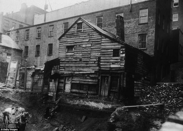 View of a back-lot house on Bleecker Street between Mercer and Greene Streets, almost toppling into an excavation site