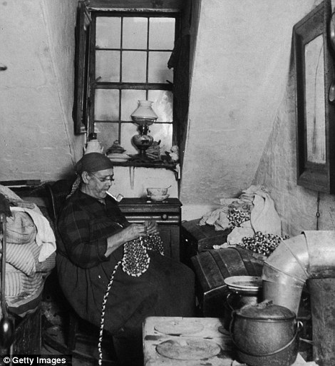 Mrs Benoit, a Native American widow, sews and beads while smoking a pipe in her Hudson Street apartment, New York City.