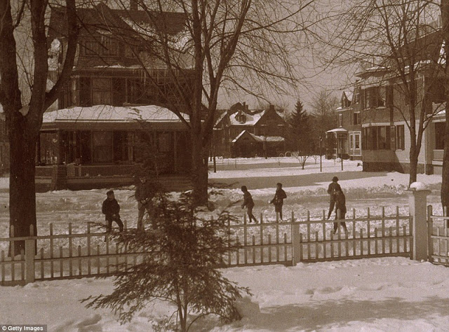 Warmly wrapped up children play in front of Dewitt Church, 280 Rivington Street, in 1890