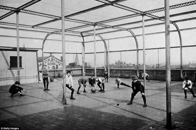 Schoolboys play with a ball on the rooftop playground