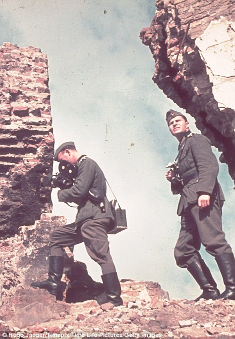 Two official Nazi photographers clamber around trying to take pictures
