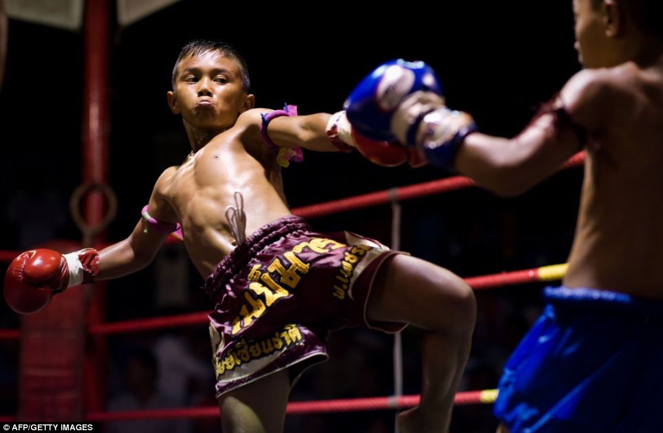 A boxer gathers all his strength as he aims a kick at his opponent