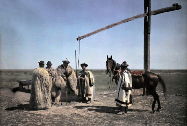 1932, Hungary, Cowboys in sheepskin and a horse center around a well in the puszta
