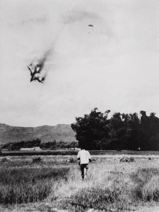 An American F-105 warplane is shot down and the pilot ejects and opens his parachute. Taken by North Vietnamese photograper Mai Nam in September 1966 near Vinh Phuc, north of Hanoi