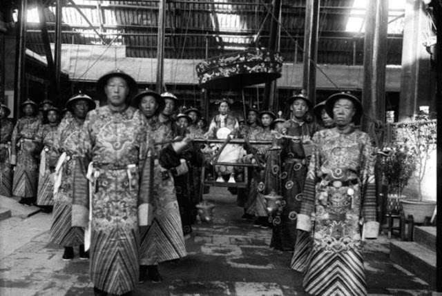 The Empress Dowager Cixi in sedan chair surrounded by eunuchs, China, Qing dynasty, 1903-1904