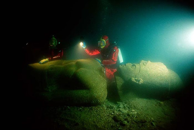 Franck Goddio and divers of his team are inspecting the statue of a pharaoh. The colossal statue is of red granite and measures over 5 metres. It was found close to the big temple of sunken Heracleion.