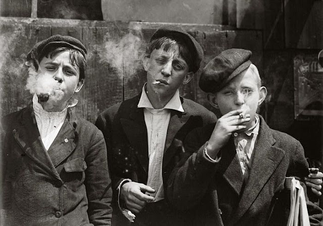 Photographer Lewis Hine shot images of young boys smoking cigarettes to emphasize the harmful effects of child labor. ca. 1880