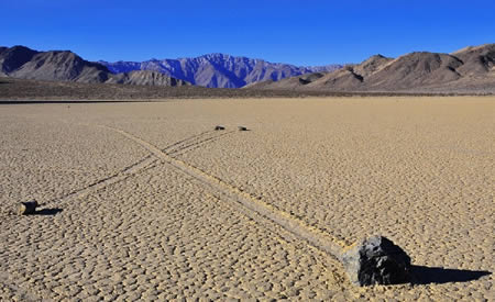 Sailing Stones    The mysterious moving stones of the packed-mud desert of Death Valley have been a center of scientific controversy for decades. Rocks weighing up to hundreds of pounds have been known to move up to hundreds of yards at a time. Some scientists have proposed that a combination of strong winds and surface ice account for these movements. However, this theory does not explain evidence of different rocks starting side by side and moving at different rates and in disparate directions. Moreover, the physics calculations do not fully support this theory as wind speeds of hundreds of miles per hour would be needed to move some of the stones.