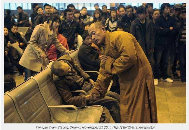 Chinese monk praying for a dead elderly man in a train station
