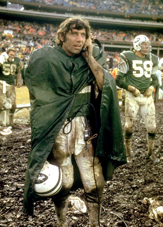 New York Jets quarterback Joe Namath listens on the sidelines during a messy New York Jets-Buffalo Bills Game. The Jets would win 20-10 behind Namaths 131 yards and two passing touchdowns.