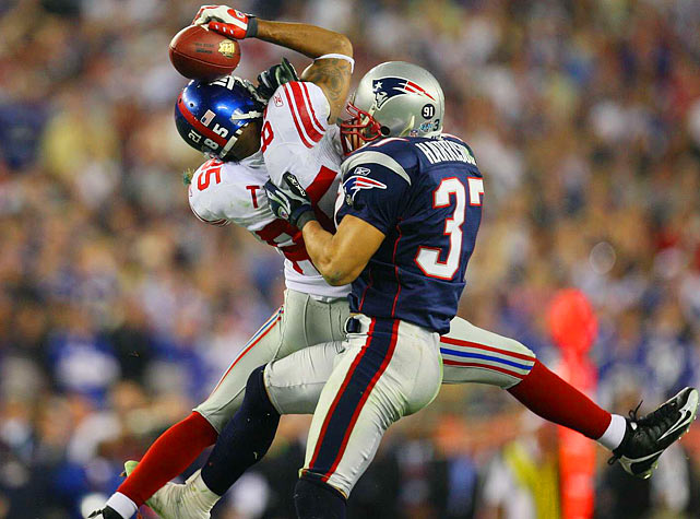 New York Giants receiver David Tyree left secures a catch with his helmet as Rodney Harrison right tries to wrestle him to the ground. Tyrees catch was instrumental in the New York Giants upset of the previously undefeated Patriots, 17-14.