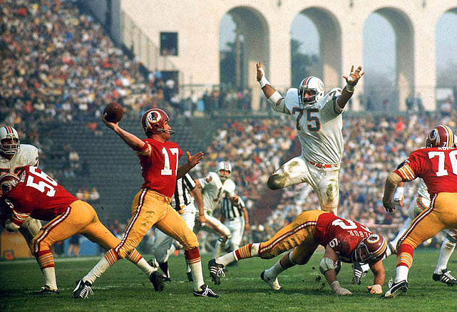Dolphins defensive lineman Manny Fernandez 75 hurdles a Redskins offensive lineman in pursuit of quarterback Billy Kilmer 17. Fernandez would finish the game with 17 tackles as the Dolphins defeated the Redskins 14-7 to become the first and last team to finish an NFL season undefeated.