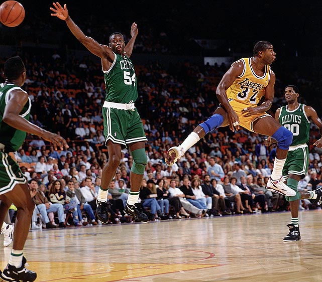 Lakers point guard Magic Johnson tosses a no-look pass past Celtics forward Ed Pinckney during a preseason game. About two weeks later, Johnson announced he was HIV-positive and retiring from basketball.