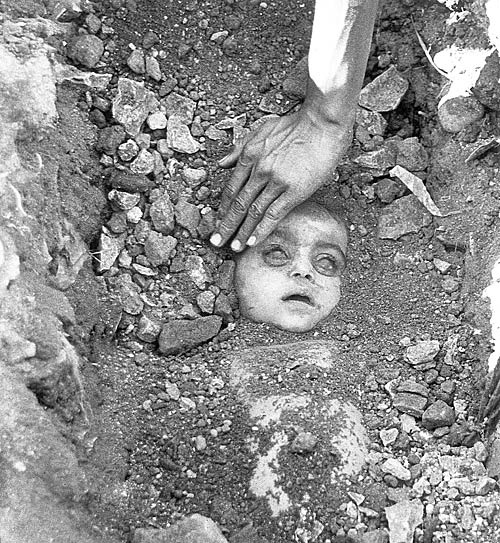 The dead body of a child is dug out who died during the gas tragedy by Union Carbide in Bhopal.