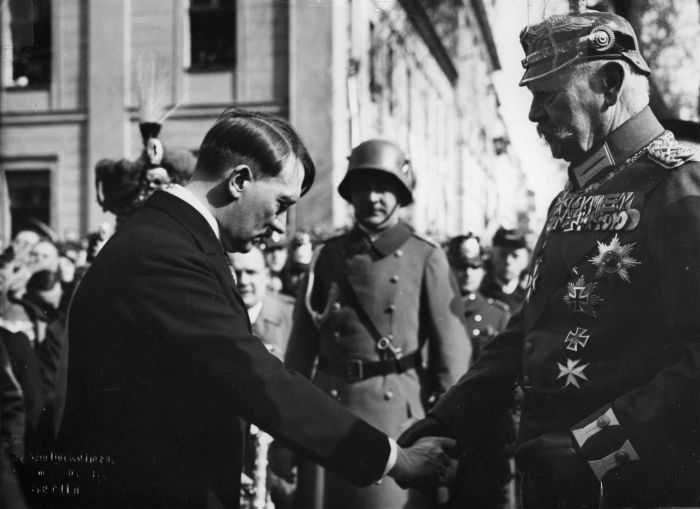 Hitler bowing deferentially as he shakes hands with Reich President Paul von Hindenburg in March, 1933