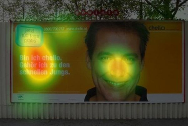 Even though theres a large picture of a mans face on this billboard, more people were looking at the words on the left.