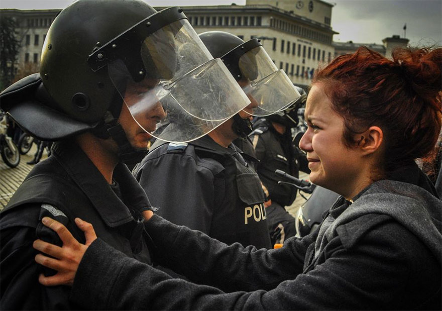Protester and riot police crying together Sofia, Bulgaria, 2013.