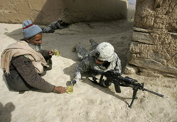 Afghan man giving tea to U.S. soldiers.