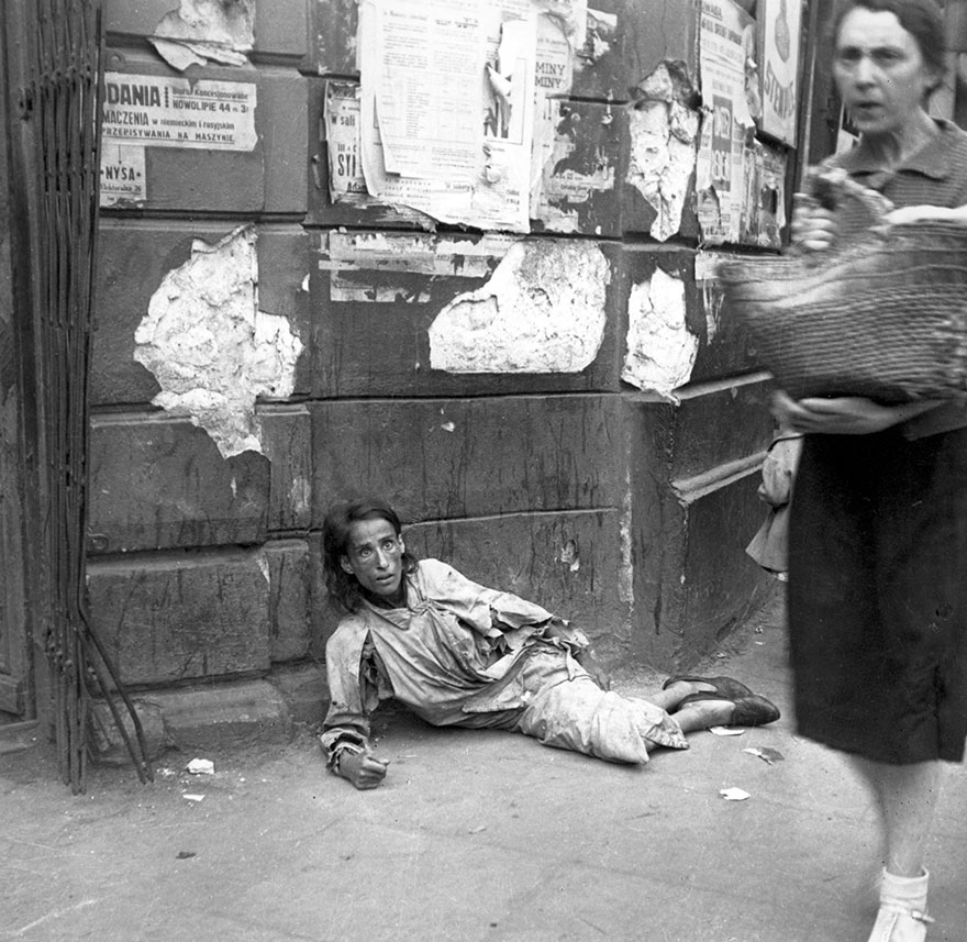 A women lying in the Warsaw ghetto, starving in Poland, 1941.