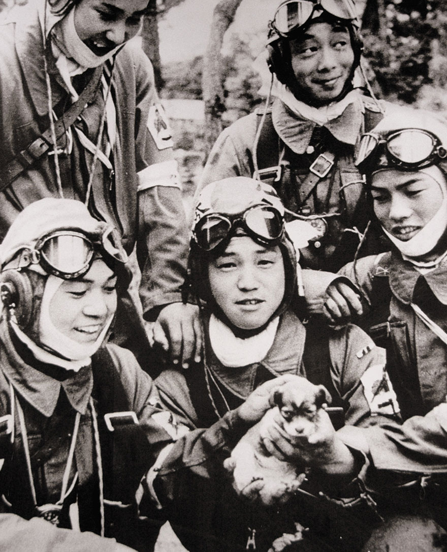 Corporal Yukio Araki, age seventeen, holding a puppy with four other young men of the 72nd Shinbu Corps the day before their departure on a Kamikaze mission in Okinawa.