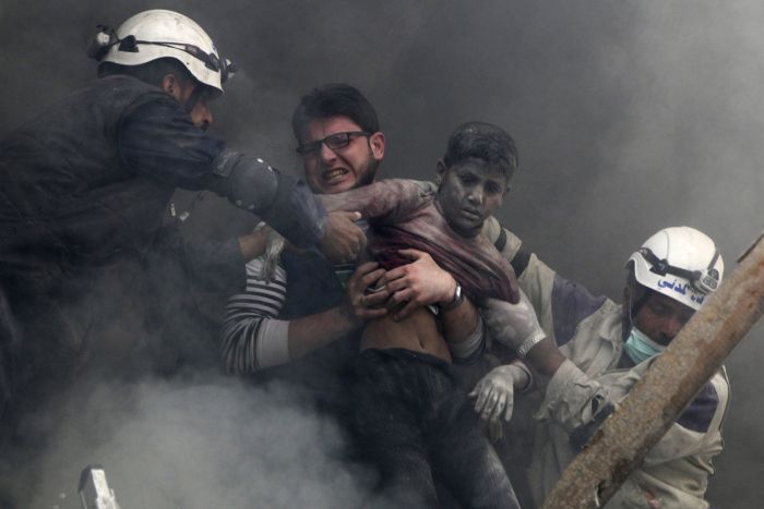 Men rescue a boy after activists said forces loyal to Syrias President Bashar Al-Assad dropped explosive barrels in Aleppo on April 6.