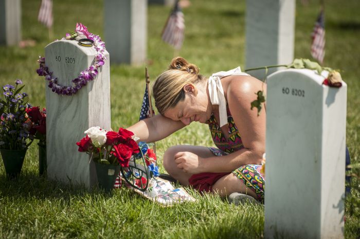 Laura Youngblood weeps over the grave of her husband, Travis L. Youngblood, during Memorial Day at Arlington National Cemetery in Virginia on May 26.